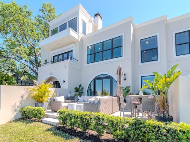 2807 W Hawthorne Rd Unit 11, Tampa, FL 33611 - rear view of property featuring stucco siding, an outdoor living space, and a patio area