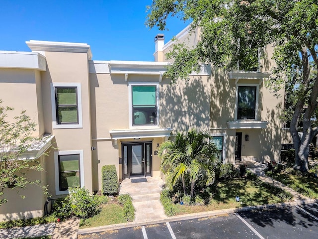 2807 W Hawthorne Rd Unit 11, Tampa, FL 33611 - view of front of home with uncovered parking, stucco siding, and a chimney