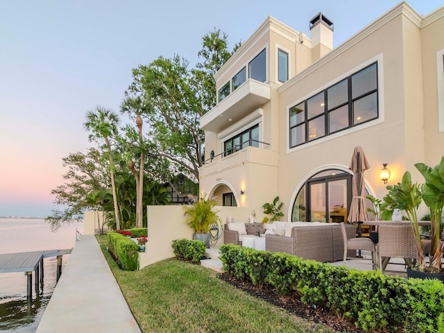 2807 W Hawthorne Rd Unit 11, Tampa, FL 33611 - back of property at dusk featuring stucco siding and an outdoor living space