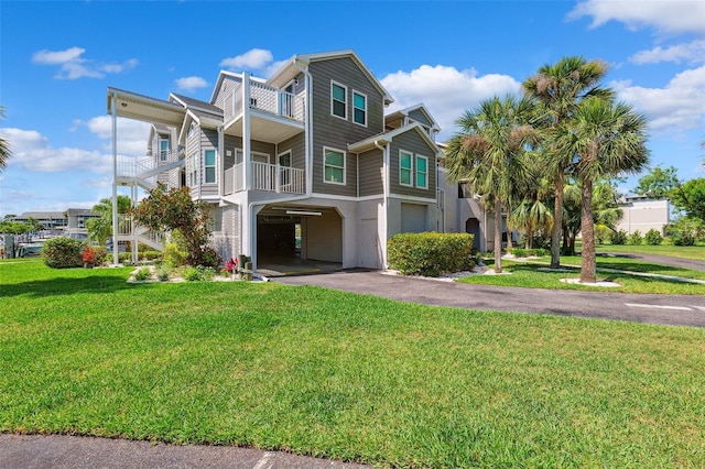 5712 Biscayne Ct Unit 103, New Port Richey, FL 34652 - view of front facade with a carport, asphalt driveway, a front lawn, and stucco siding