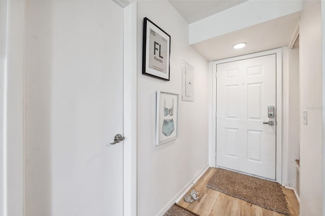 5712 Biscayne Ct Unit 103, New Port Richey, FL 34652 - doorway to outside featuring baseboards, light wood-type flooring, and electric panel