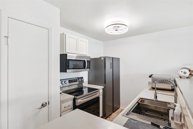 5712 Biscayne Ct Unit 103, New Port Richey, FL 34652 - kitchen with appliances with stainless steel finishes, a sink, white cabinetry, and light countertops
