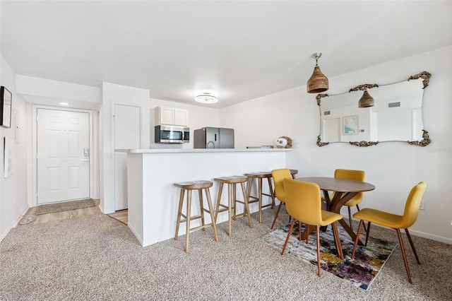 5712 Biscayne Ct Unit 103, New Port Richey, FL 34652 - dining area with baseboards and light carpet