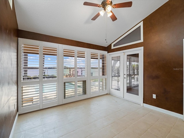 spare room with lofted ceiling, ceiling fan, baseboards, and tile patterned flooring