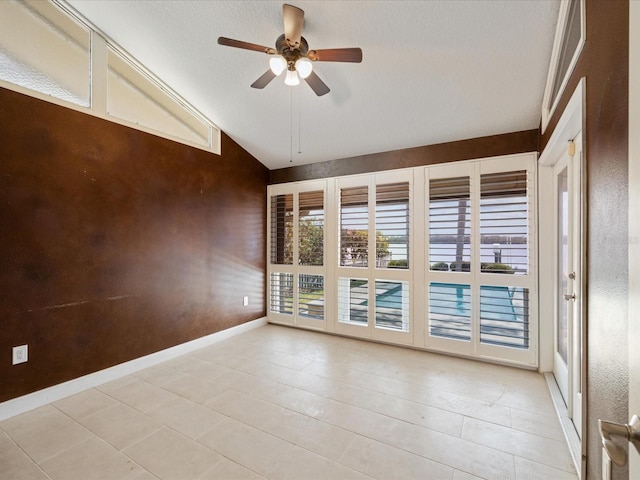unfurnished room featuring vaulted ceiling, ceiling fan, and baseboards