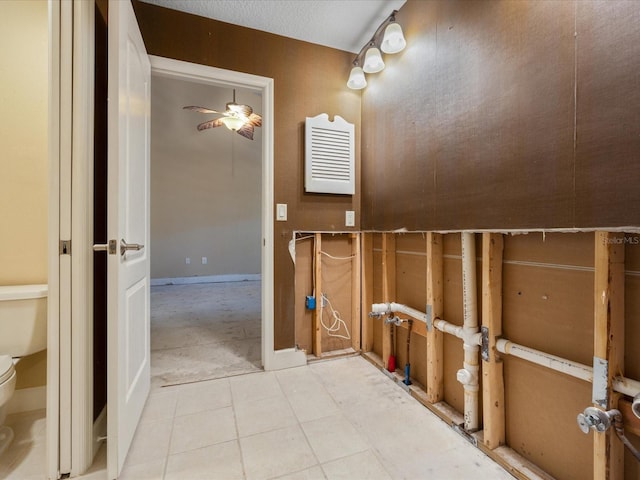 bathroom with toilet, a ceiling fan, and tile patterned floors