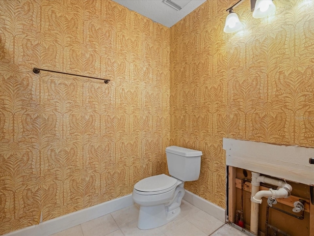 half bathroom featuring wallpapered walls, baseboards, toilet, and tile patterned floors