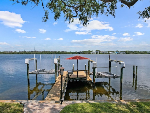 dock area with boat lift and a water view