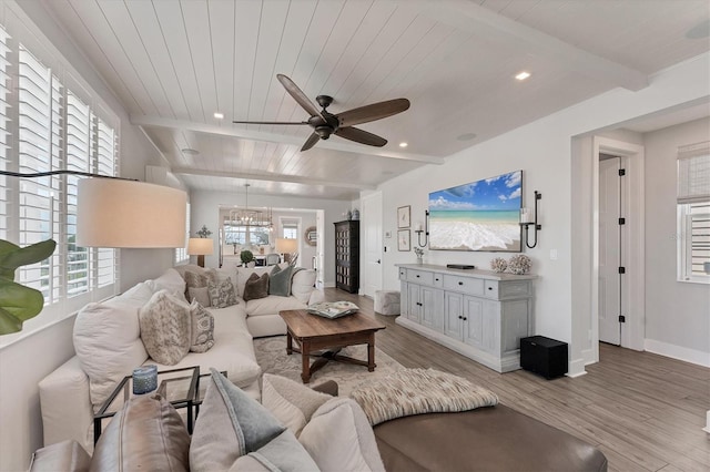 living area with beam ceiling, ceiling fan, light wood finished floors, baseboards, and wooden ceiling
