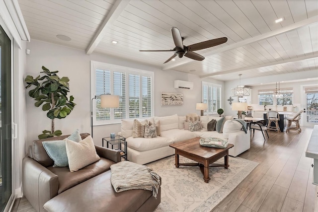 living room featuring beamed ceiling, an AC wall unit, light wood-style flooring, a ceiling fan, and wood ceiling