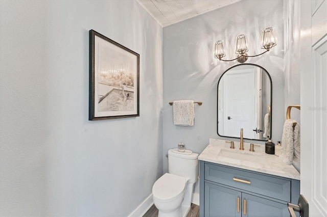 bathroom with toilet, vanity, and baseboards