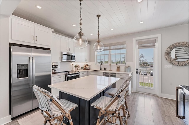 kitchen with appliances with stainless steel finishes, a sink, wood ceiling, a kitchen island, and recessed lighting