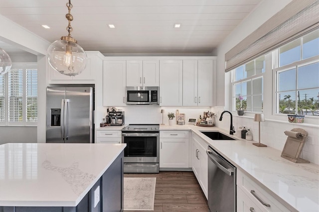 kitchen featuring stainless steel appliances, a sink, dark wood-style floors, and decorative backsplash