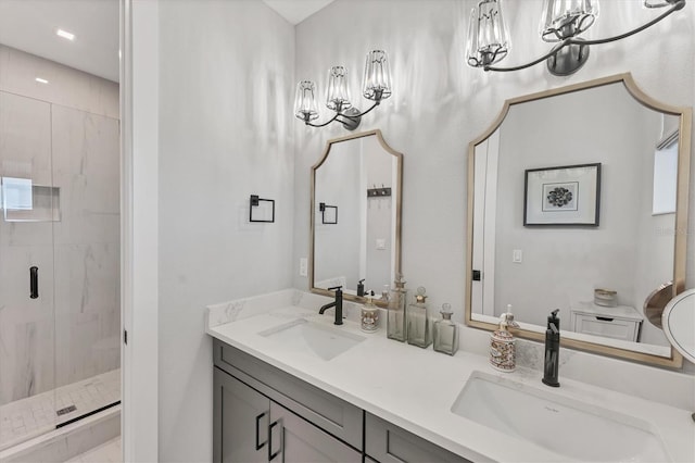 bathroom with a marble finish shower, double vanity, and a chandelier