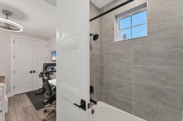 full bath featuring wood finished floors and shower / washtub combination