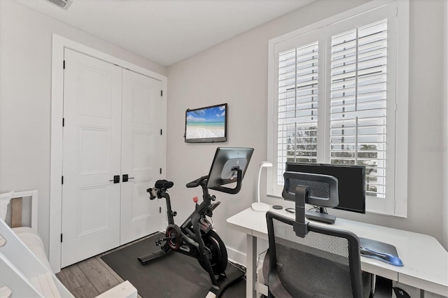 workout area featuring wood finished floors and baseboards
