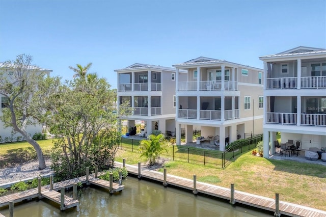 view of building exterior with a water view and a fenced backyard