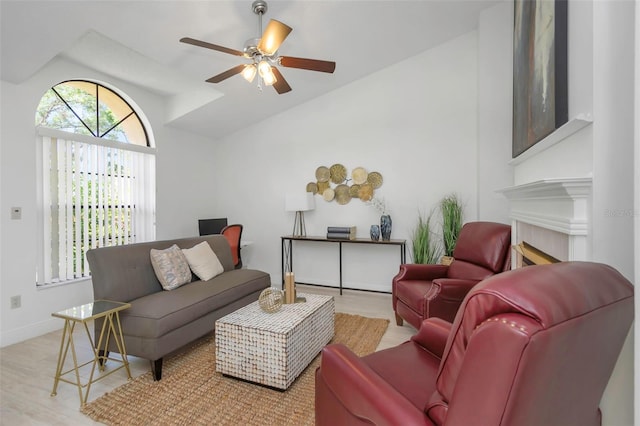 living room featuring lofted ceiling, a ceiling fan, wood finished floors, and baseboards