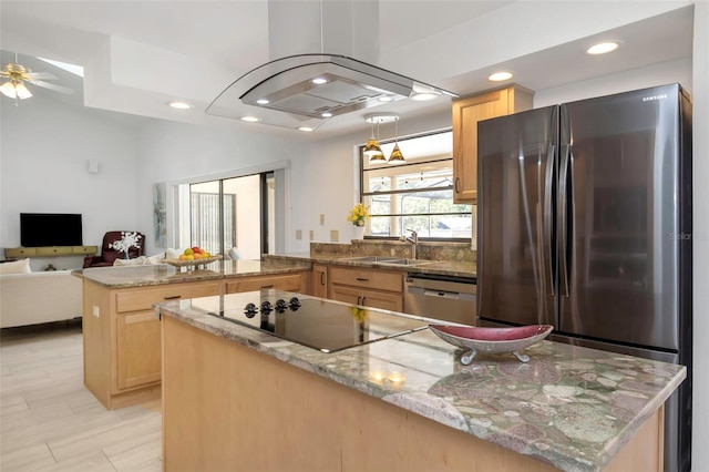 kitchen featuring appliances with stainless steel finishes, light brown cabinets, a peninsula, a sink, and open floor plan