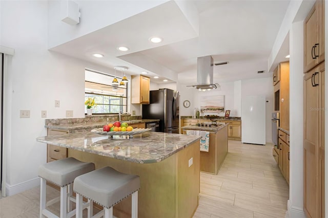 kitchen with freestanding refrigerator, island range hood, a kitchen island, oven, and a peninsula