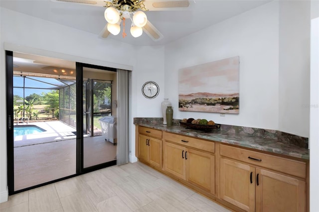 doorway with ceiling fan and a sunroom
