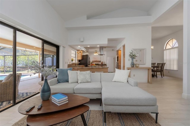 living area featuring high vaulted ceiling and baseboards