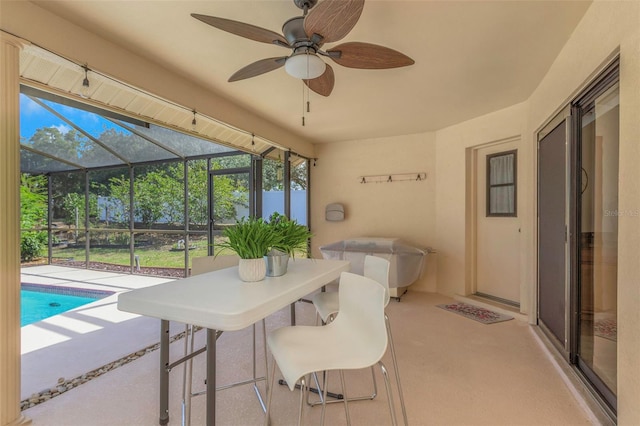 sunroom featuring ceiling fan and plenty of natural light