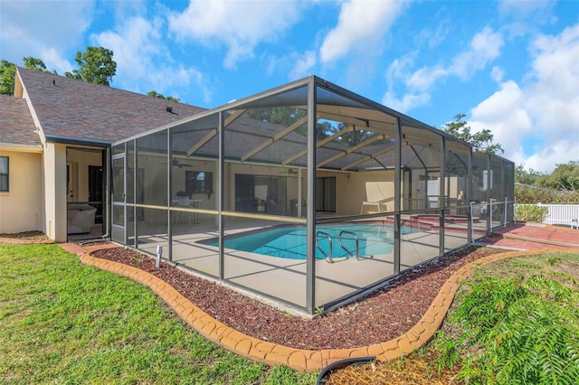view of pool featuring a patio area, ceiling fan, a lanai, and a lawn