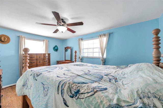 3621 Beacon Square Dr, Holiday, FL 34691 - bedroom with multiple windows, wood finished floors, ceiling fan, and baseboards