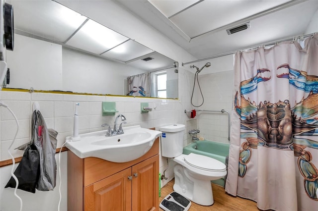 3621 Beacon Square Dr, Holiday, FL 34691 - full bath with tile walls, wood finished floors, vanity, shower / tub combo with curtain, and toilet