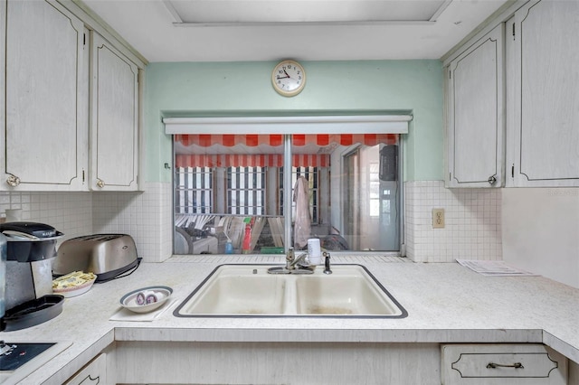 3621 Beacon Square Dr, Holiday, FL 34691 - kitchen with a sink, light countertops, decorative backsplash, and electric stovetop