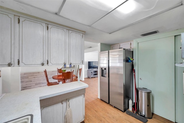 3621 Beacon Square Dr, Holiday, FL 34691 - kitchen with stainless steel refrigerator with ice dispenser, light countertops, and light wood-style floors
