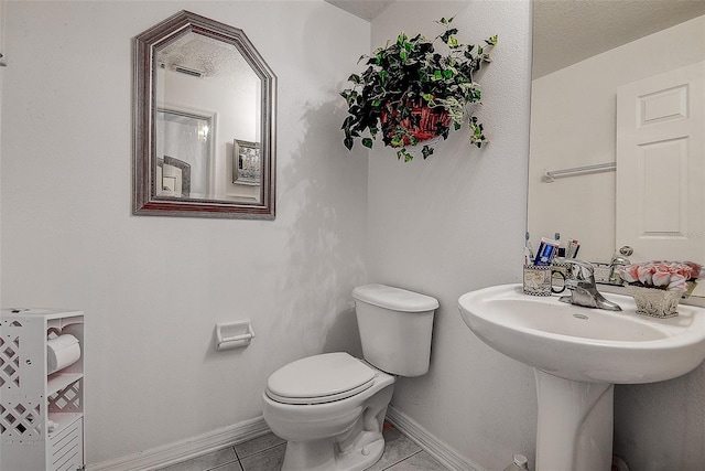 14985 Alan Ct, Largo, FL 33771 - bathroom featuring toilet, tile patterned floors, baseboards, and a sink