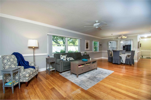 living room featuring ceiling fan, light wood-style floors, baseboards, and ornamental molding