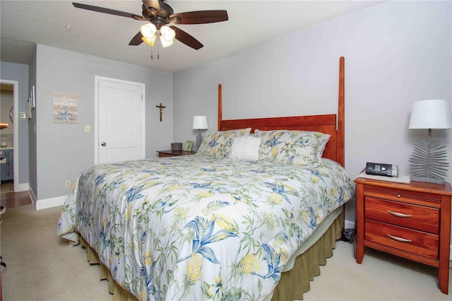 bedroom with light colored carpet, baseboards, and ceiling fan
