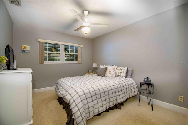 bedroom featuring light carpet, baseboards, and a ceiling fan