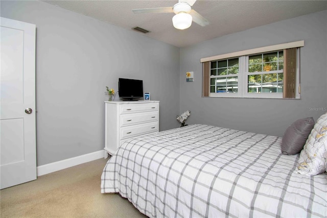 bedroom featuring carpet flooring, baseboards, a textured ceiling, and ceiling fan