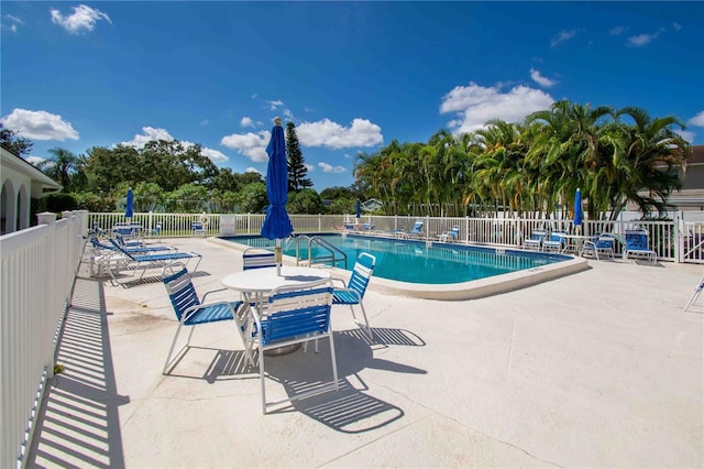 community pool featuring fence and a patio area