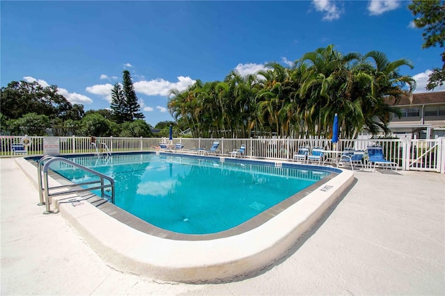 community pool with fence and a patio
