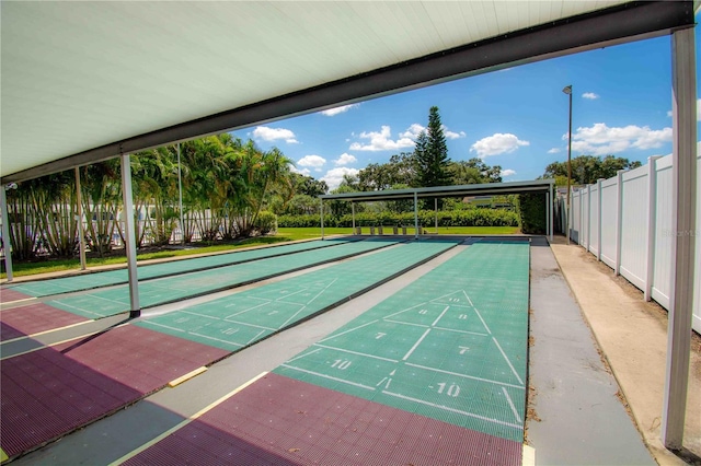 view of home's community with fence and shuffleboard