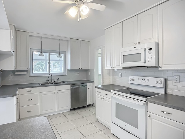 904 Desert Hills Dr, Sun City Center, FL 33573 - kitchen featuring white appliances, dark countertops, a ceiling fan, tasteful backsplash, and white cabinetry