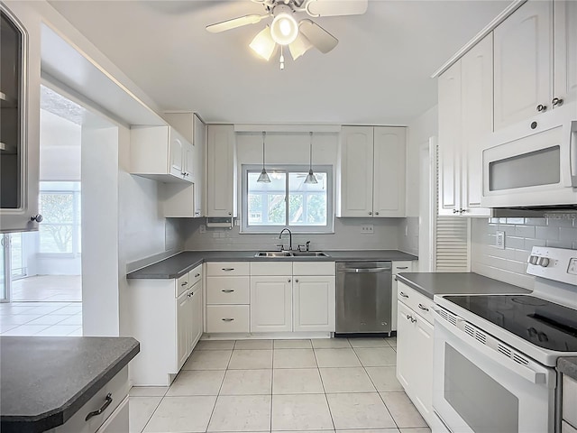 904 Desert Hills Dr, Sun City Center, FL 33573 - kitchen featuring white appliances, dark countertops, light tile patterned flooring, tasteful backsplash, and ceiling fan