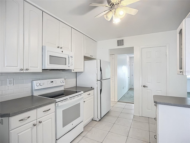 904 Desert Hills Dr, Sun City Center, FL 33573 - kitchen with white appliances, dark countertops, white cabinets, ceiling fan, and light tile patterned floors