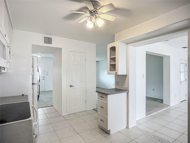904 Desert Hills Dr, Sun City Center, FL 33573 - kitchen featuring dark countertops, white cabinetry, ceiling fan, light tile patterned flooring, and white appliances