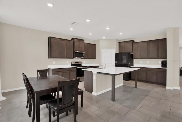 10379 Bridgegate Heights Loop, San Antonio, FL 33576 - kitchen featuring appliances with stainless steel finishes, a sink, dark brown cabinetry, baseboards, and recessed lighting
