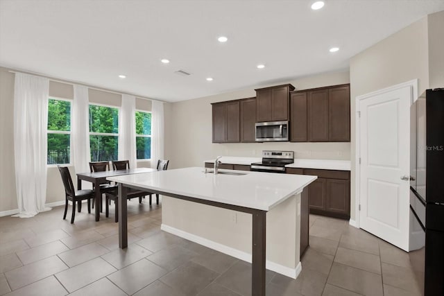 10379 Bridgegate Heights Loop, San Antonio, FL 33576 - kitchen with stainless steel appliances, a sink, light countertops, dark brown cabinets, and recessed lighting