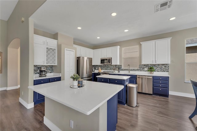 1530 The Oaks Blvd, Kissimmee, FL 34746 - kitchen featuring blue cabinets, appliances with stainless steel finishes, a center island, dark wood-style flooring, and recessed lighting