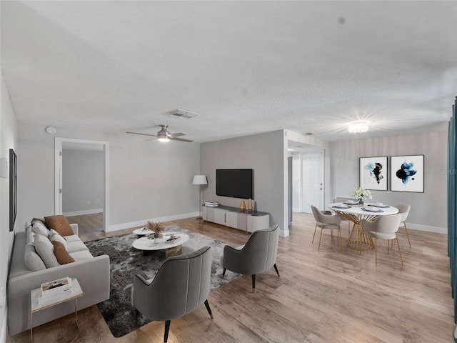 4238 Glissade Dr, New Port Richey, FL 34652 - living room with light wood-style flooring, a ceiling fan, baseboards, and a textured ceiling