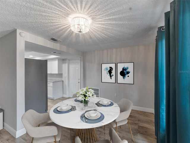 4238 Glissade Dr, New Port Richey, FL 34652 - dining room featuring baseboards, light wood-type flooring, and a textured ceiling
