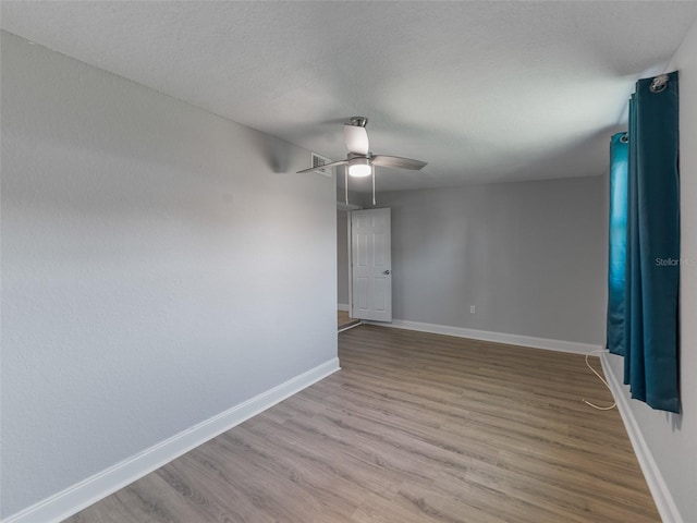 4238 Glissade Dr, New Port Richey, FL 34652 - unfurnished room featuring wood finished floors, ceiling fan, baseboards, and a textured ceiling